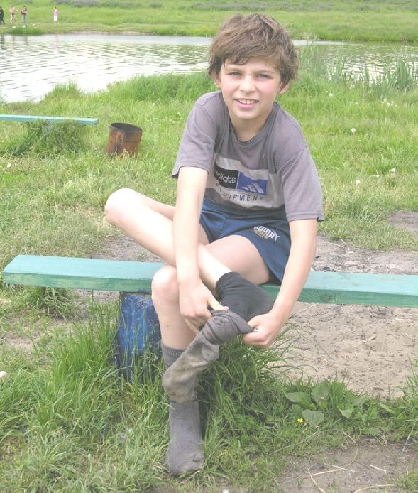 Junge mit dicken Socken auf der Wiese