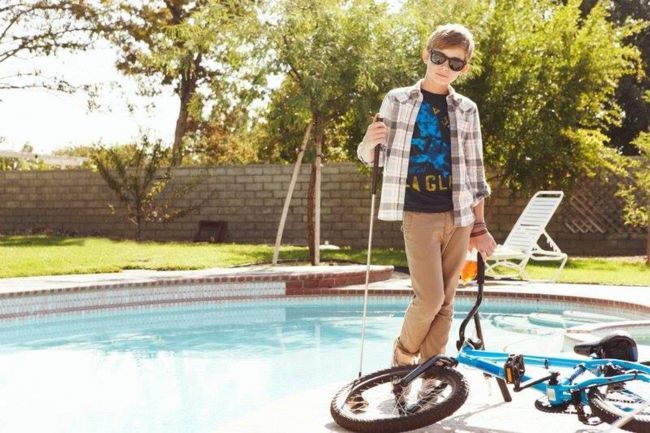cooler Junge mit Rad am Pool 02